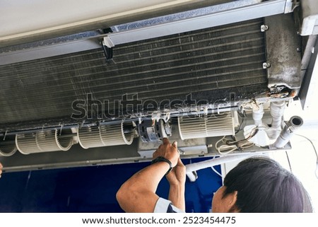Air- con technician repairing or fixing air conditioner