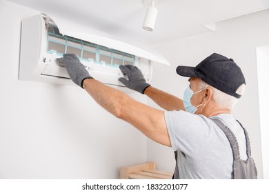 Air Conditioner Cleaning. Worker In Gloves And Medical Mask Checks Filter.