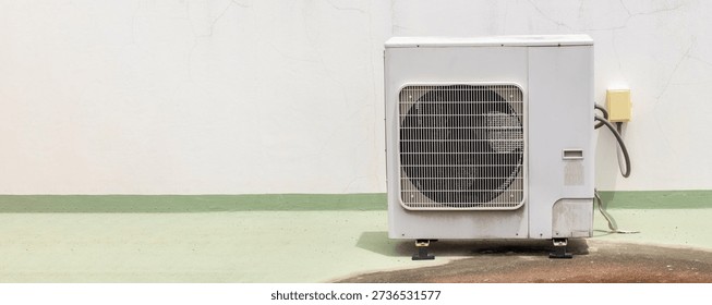 Air conditioner compressor installed in old building. Outdoor split wall type air conditioner compressor unit inverter installed on the outside of the building. Air conditioner compressor outdoor unit
