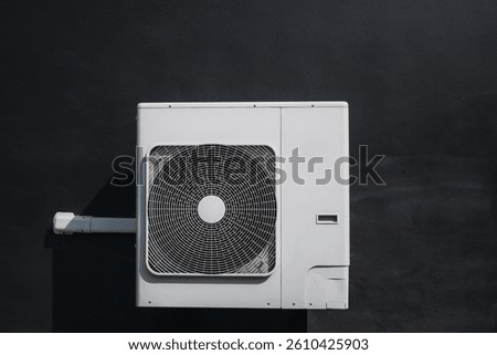 Air conditioner compressor installed on the wall of a building.