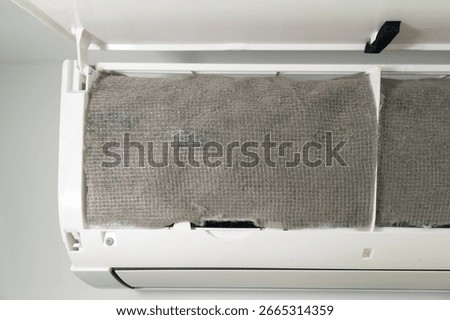 Air conditioner dust filter screen covered with old dirty HEPA filter fabric after capturing fine dust particles. Concepts of HVAC system, air purification, health, cleaning and home appliance service