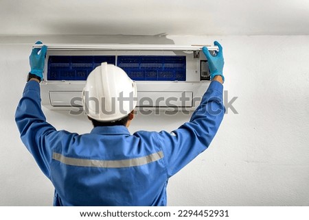 Air conditioner maintenance technician checks the cleanliness of the air conditioner inside the house.