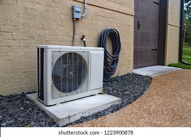 Air Conditioner Mini Split System Next To Home With Painted Brick Wall