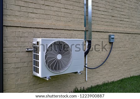 Air Conditioner mini split system mounted on brick wall with space for text copy