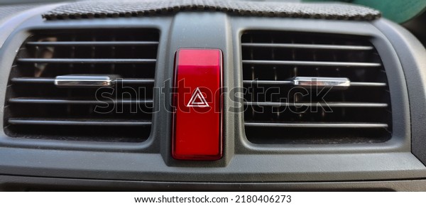 air conditioner outlet grill inside a car\
with red emergency button or hazard\
button