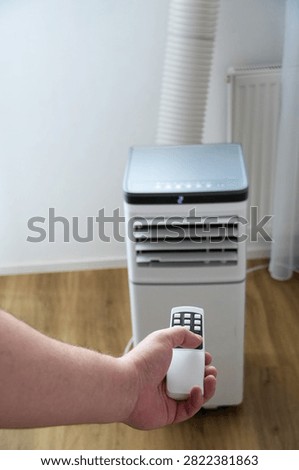 Air conditioner remote control in hand on white background. Air conditioner on. 