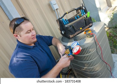 Air Conditioner Repair Man.  Using testing equipment on outside unit. - Shutterstock ID 183731408
