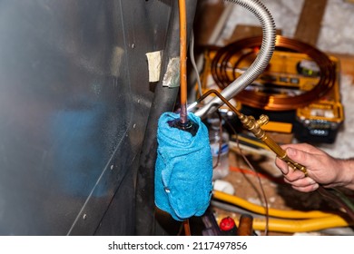 Air Conditioner Technician using a brazing torch to repair equipment