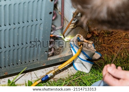Air Conditioner Technician using a brazing torch to repair equipment