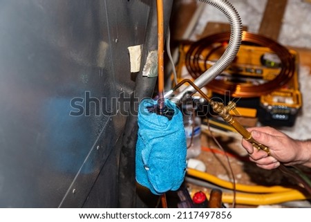 Air Conditioner Technician using a brazing torch to repair equipment