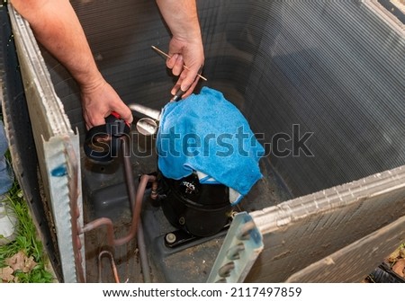 Air Conditioner Technician using a brazing torch to repair equipment