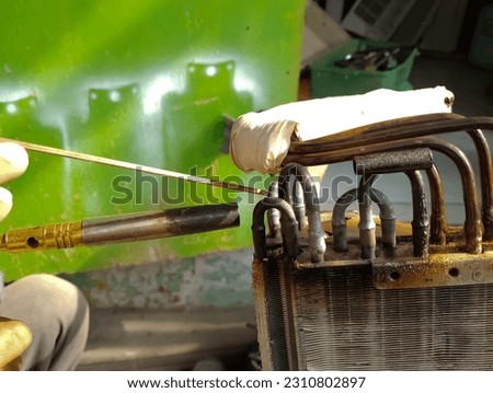 Air Conditioner Technician using a brazing torch to repair equipment