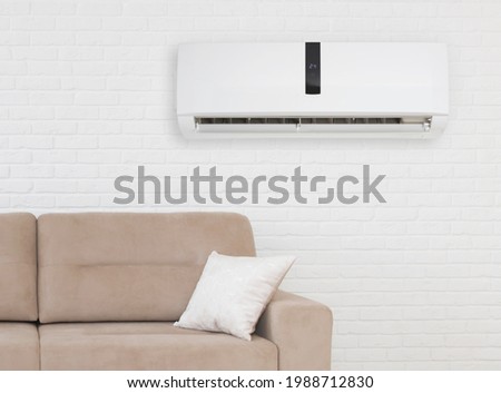 Air conditioner with temperature display above sofa in living room