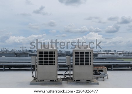 Air conditioner units HVAC on a roof of industrial building with blue sky.