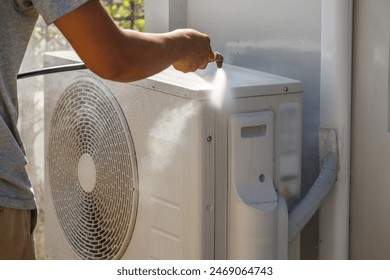 air conditioning compressor outdoor unit cleaning service with water spray - Powered by Shutterstock