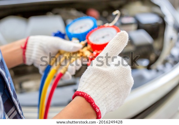 Air Conditioning Repair, Repairman giving thumbs\
up and holding monitor tool to check and fixed car air conditioner\
system, Technician check car air conditioning system refrigerant\
recharge
