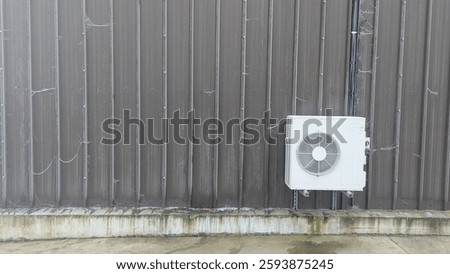 Air conditioning unit mounted on wall of industrial warehouse corrogated brown wall machinery