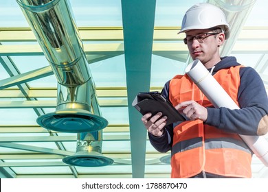 Air Conditioning And Ventilation. Ventilation System. Maintenance Of The Ventilation System In The Building. Air Conditioning Repairman With A Tablet In His Hands. 