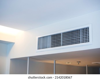 Air conditioning wall mounted ventilation system on ceiling in the white hotel room. Hotel room air ventilation grill on the wall.