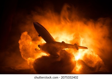 Air Crash. Burning falling plane. The plane crashed to the ground. Decorated with toy at dark fire background. Air accident concept. Selective focus