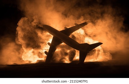Air Crash. Burning falling plane. The plane crashed to the ground. Decorated with toy at dark fire background. Air accident concept. Selective focus