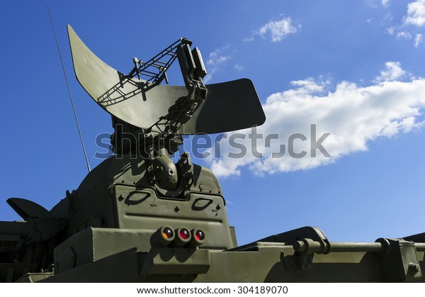Air defense radar of military mobile mighty\
rocket launcher system of green color, modern army industry, white\
cloud and blue sky on background\
