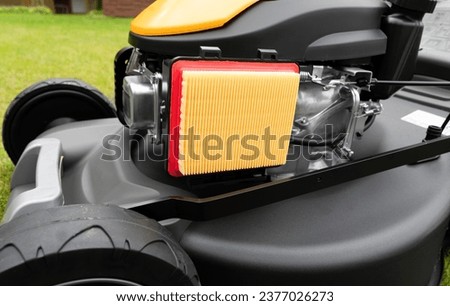 Air filter on gas powered lawn mower. Checking air cleaner filter for proper maintenance. Air filter on lawn mower tractor. Small engine repair, maintenance