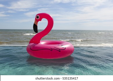 Air flamingos balloon float in the swimming pool by the sea