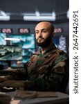 Air force combat control officer performing tactical level surveillance in headquarters, using satellite equipment. Military expert using radar technology to search for potential assault zones