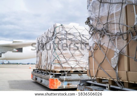 air freight cargo on dolly trailer waiting to be loaded onto aircraft