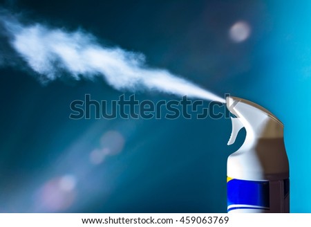 Air freshener spray aerosols in action in the light of sun on blue background