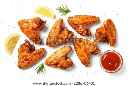 Air fryer chicken wings glazed with hot chilli sauce and served with different sauces.  isolated on white  background . top view