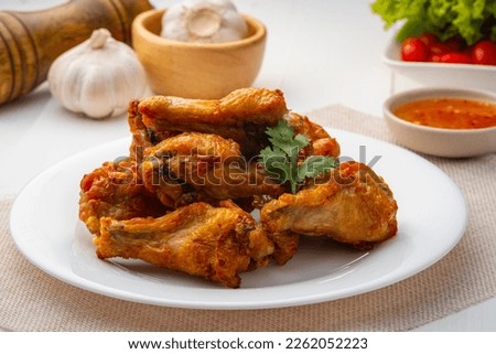 Air Fryer drummet chicken wing with Fish Sauce on white plate,less oil frying and crispy
