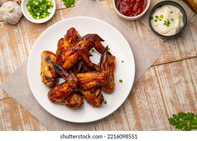 Air Fryer Grilled Chicken Wings On White Plate,served With Ketchup And Mayonnaise.Top View