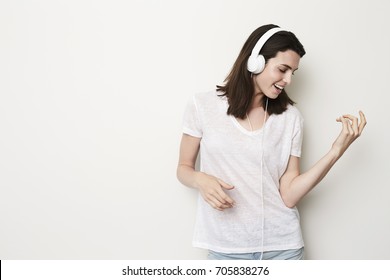 Air Guitar Girl Playing To Headphones In Studio