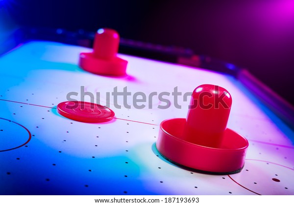 Air hockey table with dramatic lighting on a\
dark background