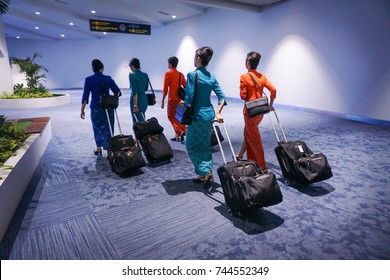 Air Hostess In International Airport, Walking With Her Luggage, Back View. Flight Attendant Going To Meet Her Crew