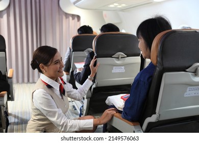 air hostess service on plane , flight attendant checking and closing cabin compartment in airplane - Shutterstock ID 2149576063