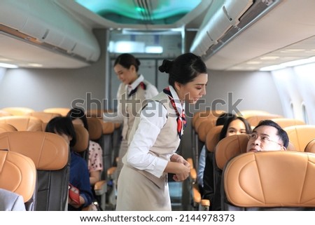 air  hostess service on plane , flight attendant checking and closing cabin compartment in airplane
