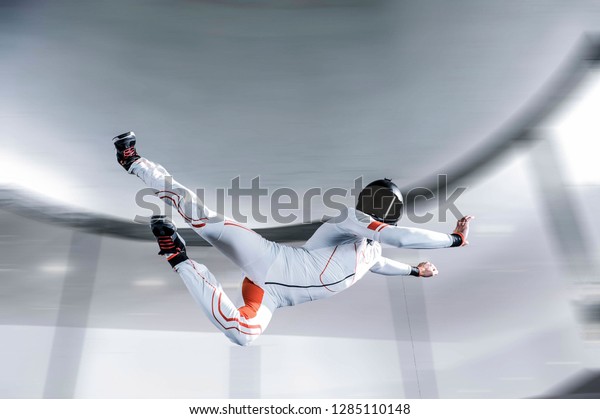 Air indoor skydiving sports Dubai UAE.flying people in\
Dubai wind tunnel . indoor skydiving air. Ninja men in white suit.\

