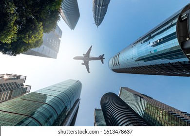 Air plane flying low over highrise office buildings in downtown of Malaysia City