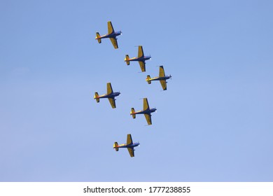 Air Planes of Hawks of Romania aerobatic team of the Romanian Aeroclub with 6 Extra Flugzeugbau EA 300, performing acrobatic flight on blue sky.