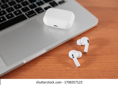 Air Pods Pro. macbook. with Wireless Charging Case. New Airpods pro on wooden background. Airpods. Copy space
