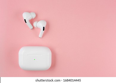 Air Pods pro. with Wireless Charging Case. New Airpods pro on pink background. Airpodspro. female headphones. entangled 3.5 headphones. Copy Space