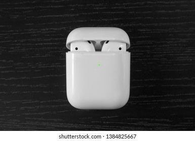 Air Pods. with Wireless Charging Case. New Airpods 2019 on black background. Airpods.EarPods