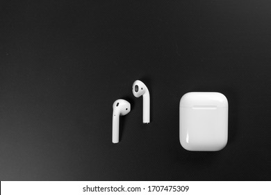 Air Pods. with Wireless Charging Case. New Airpods 2019 on black background. Airpods. Copy space