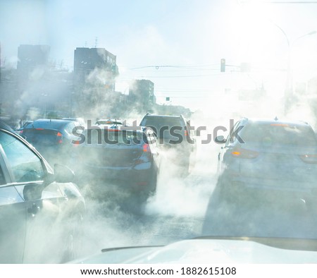 air pollution from the exhaust of cars in the city during the cold day, environmental pollution in the city