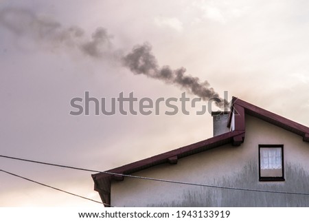 Air pollution house chimney smoke global warming concept on sunset sky