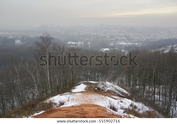 Air pollution\
and smog in Ostrava city. Cityscape view from Ema slag heap, heavy\
and dark fog limits visibility. Winter season with snow and bare\
tree (dark exposure,\
desaturation)