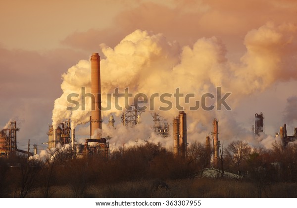 Air pollution\
from smoke stacks at oil\
refinery
